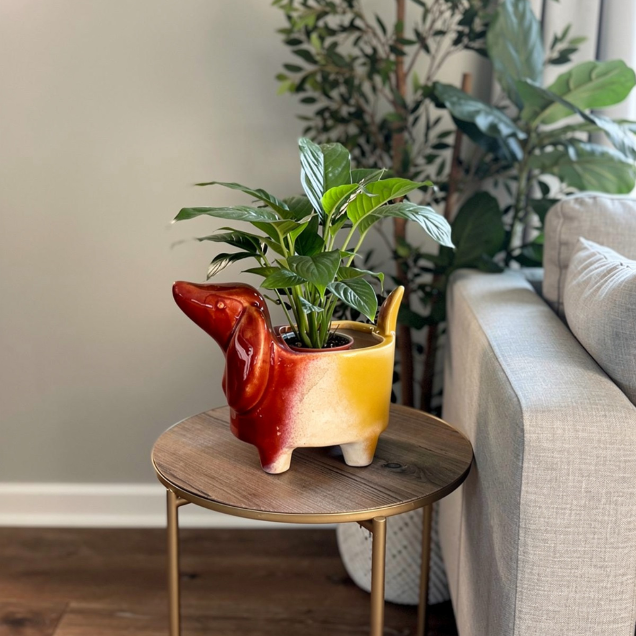 Red and yellow dog-shaped planter with a plant on a wooden side table in a living room.