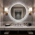 Bathroom vanity with round illuminated mirror, marble countertop, and wall lights.