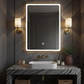 Bathroom vanity with illuminated mirror, sink, and decorative items.