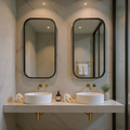 Bathroom vanity with two round sinks, mirrors, and decorative items.