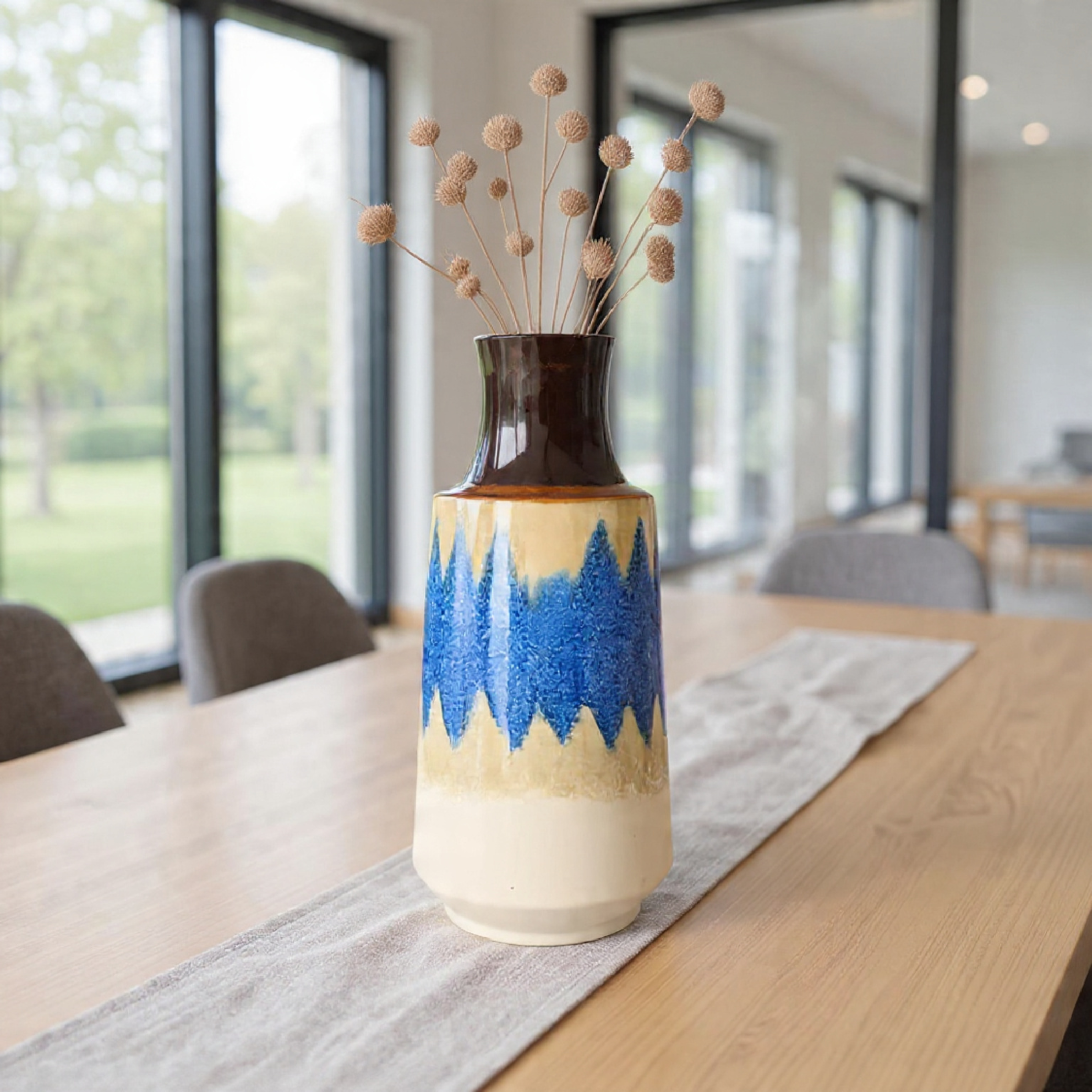 Decorative vase with blue and beige design on a table in a modern room.