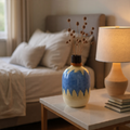 Decorative vase with blue and white design on a table in a living room setting.