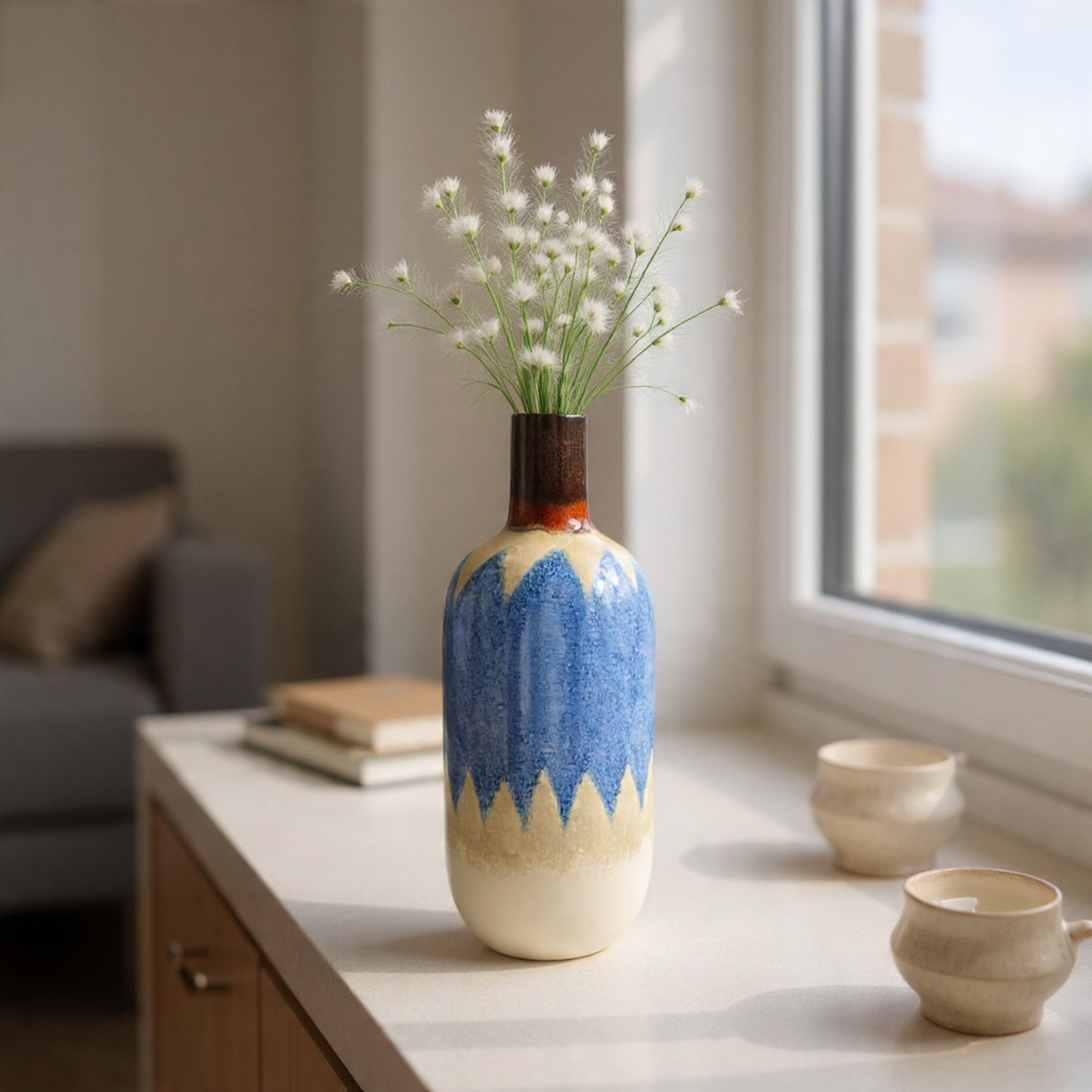 Decorative vase with blue and beige pattern on a table near a window