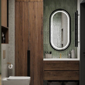 Bathroom with wooden vanity, toilet, and mirror with lighted frame.