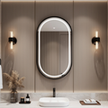 Bathroom vanity with a mirror, lights, and decorative items.