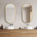 Bathroom vanity with two oval mirrors and wooden cabinets.